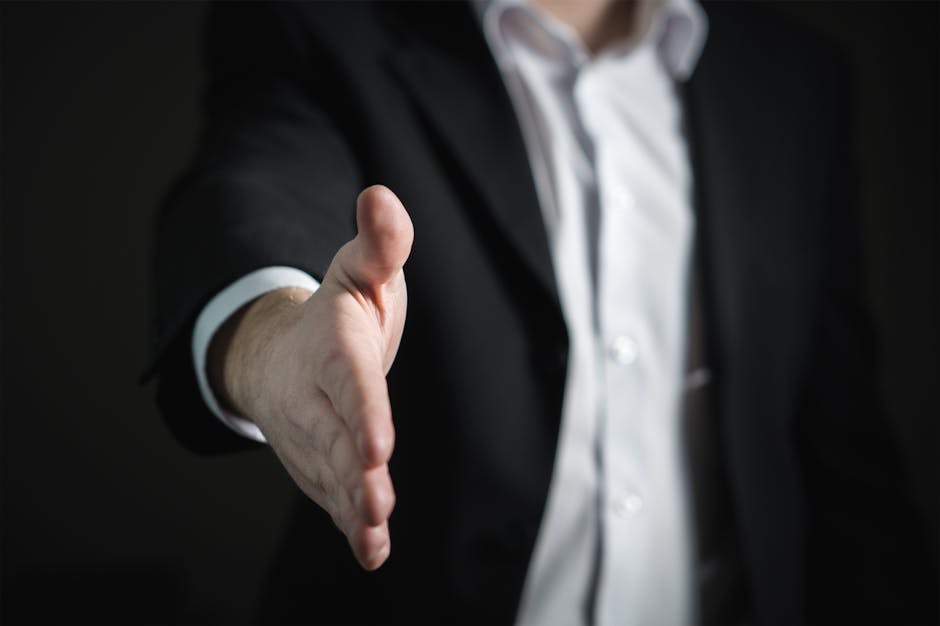 Close-up of a businessman extending hand for a handshake, symbolizing agreement and partnership